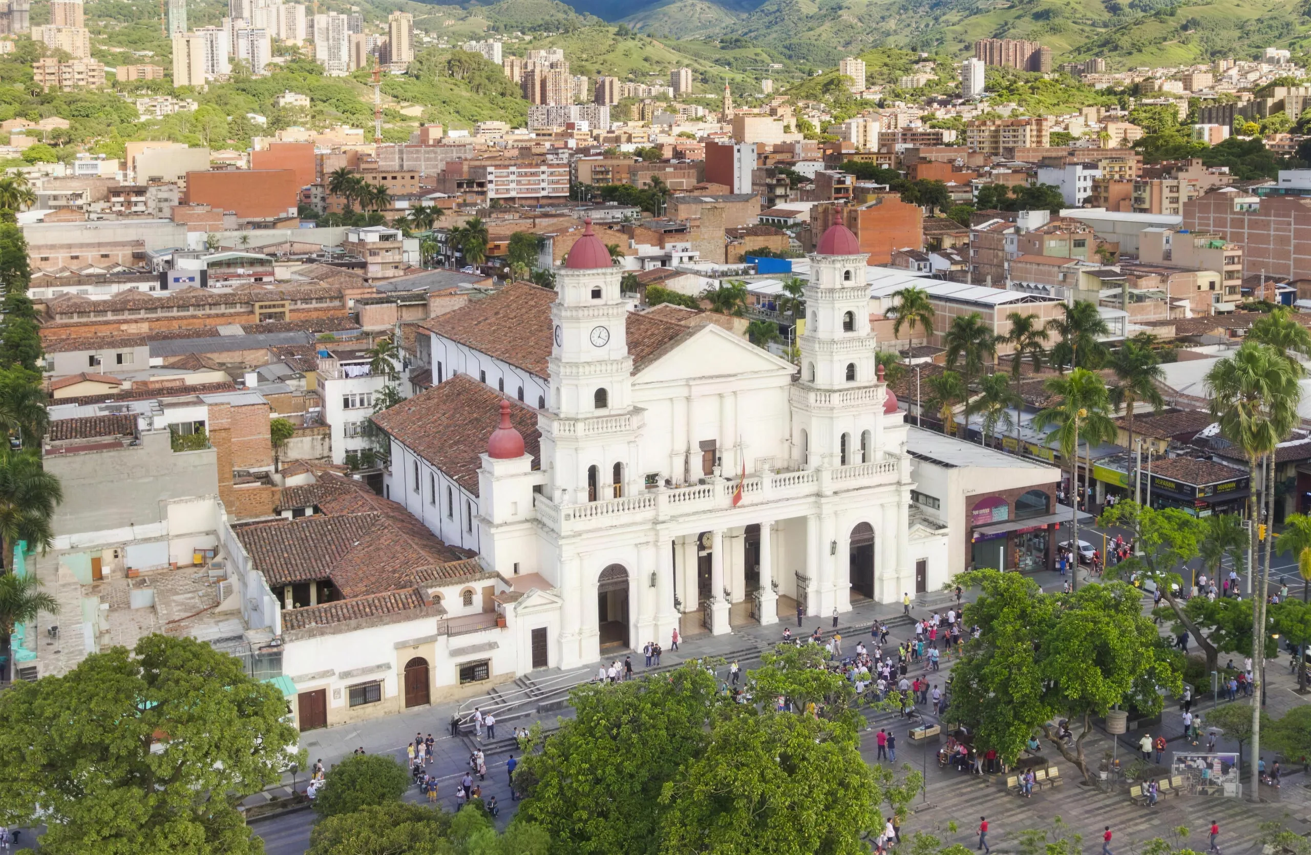 La catedral blanca y el parque principal de Envigado, el pueblo extendido sobre las colinas verdes de Medellín
