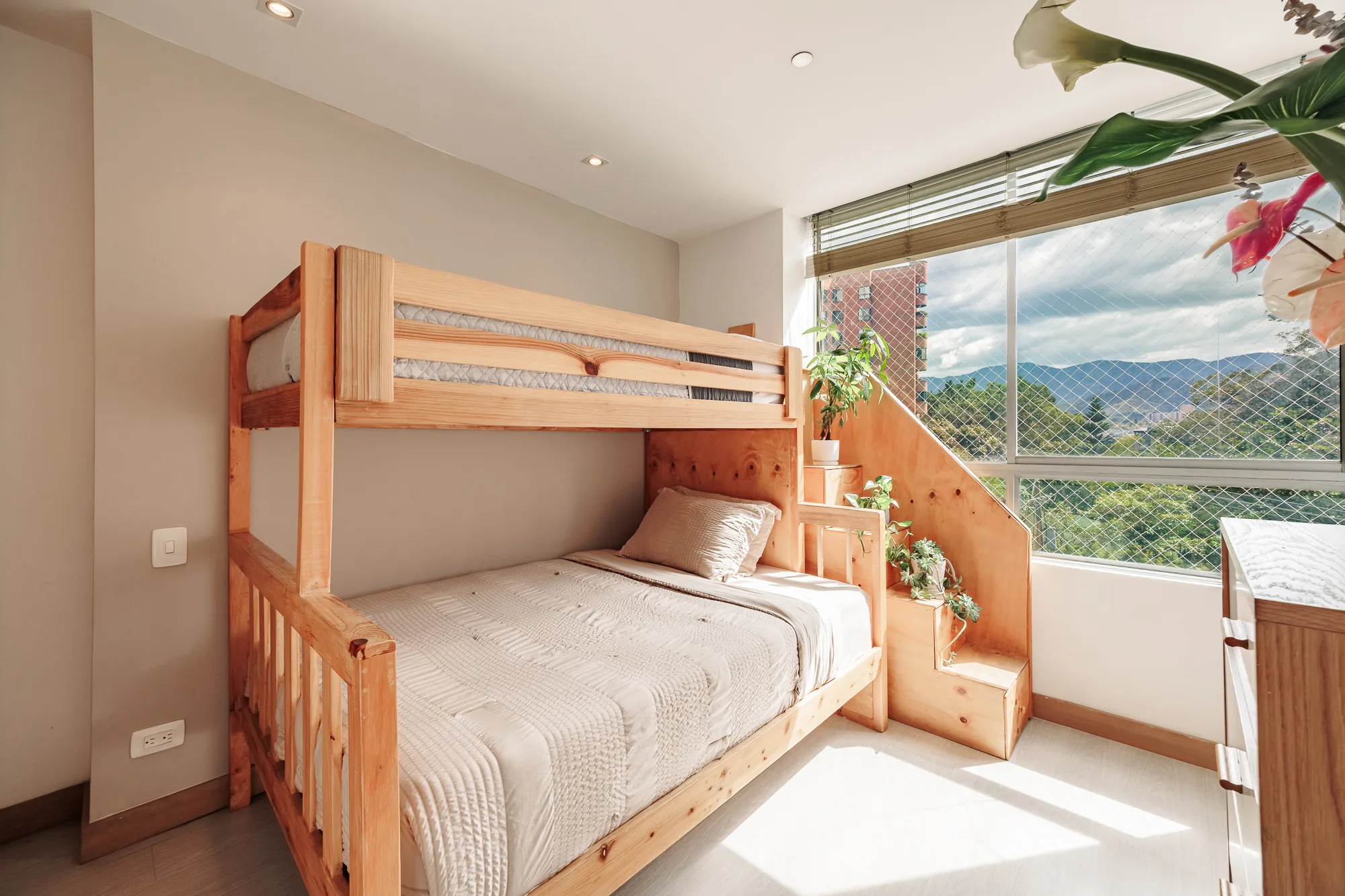 Third bedroom with wooden bunk beds and a mountain-view window at Balcón Verde