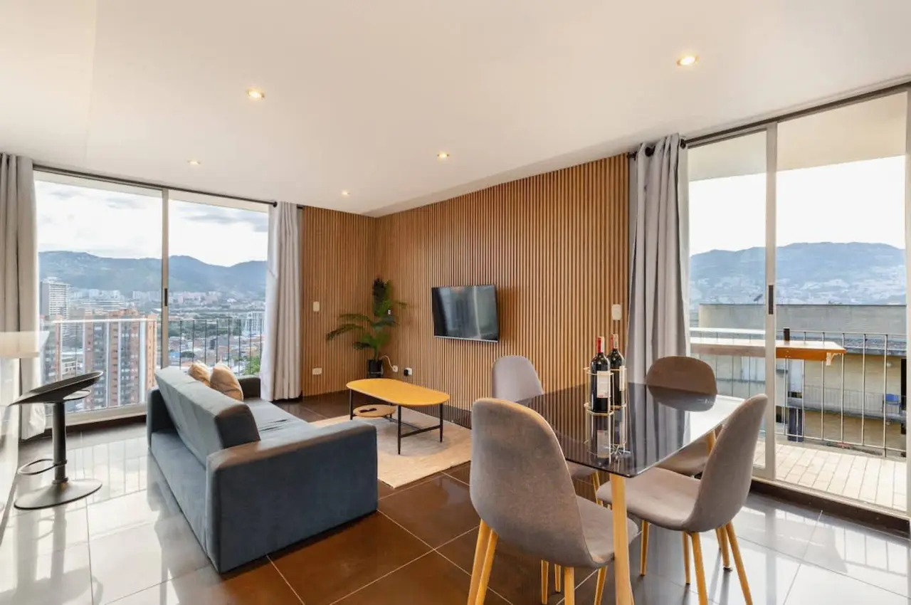 Living and dining under the slatted timber wall, with the city through the full-height glass