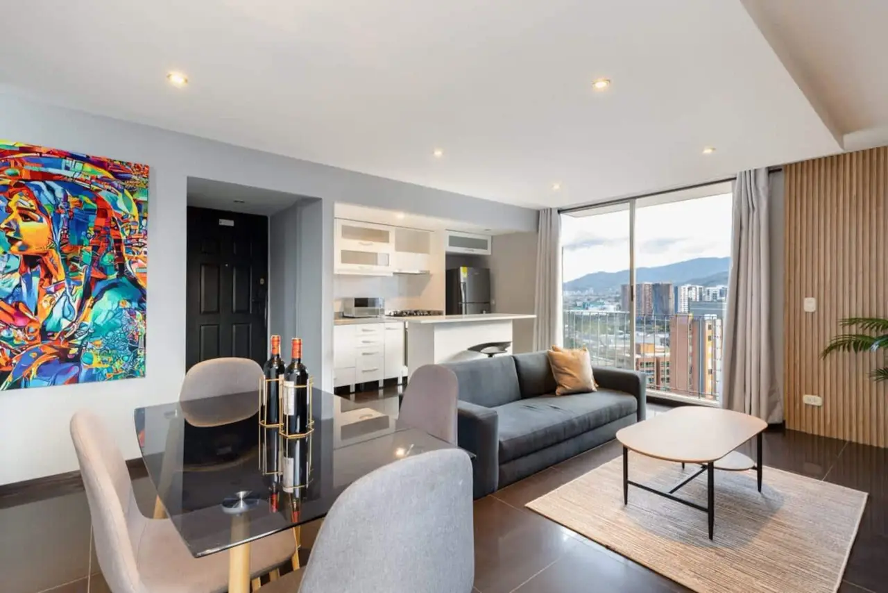 Living room and open kitchen, with a large portrait canvas by the door