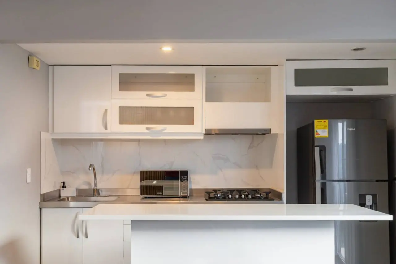Kitchen counter, gas hob and tall fridge