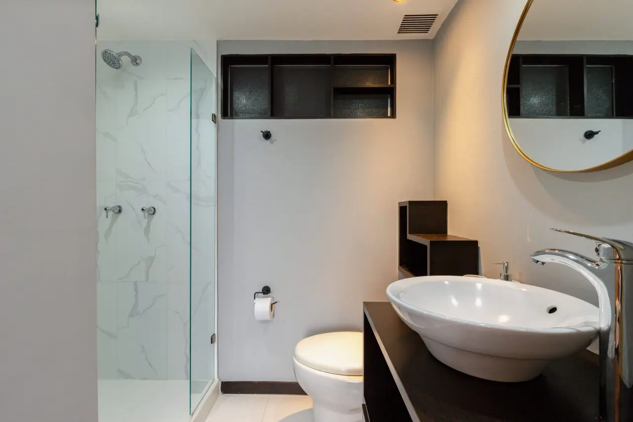 The second bathroom, with a glass shower and marble tiling