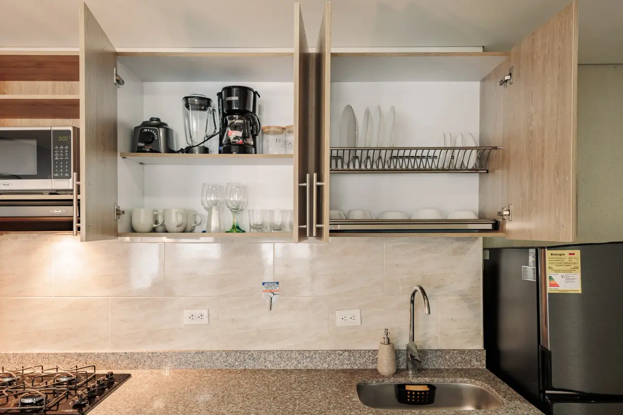 Open kitchen shelves with glassware, coffee maker and everyday dishes