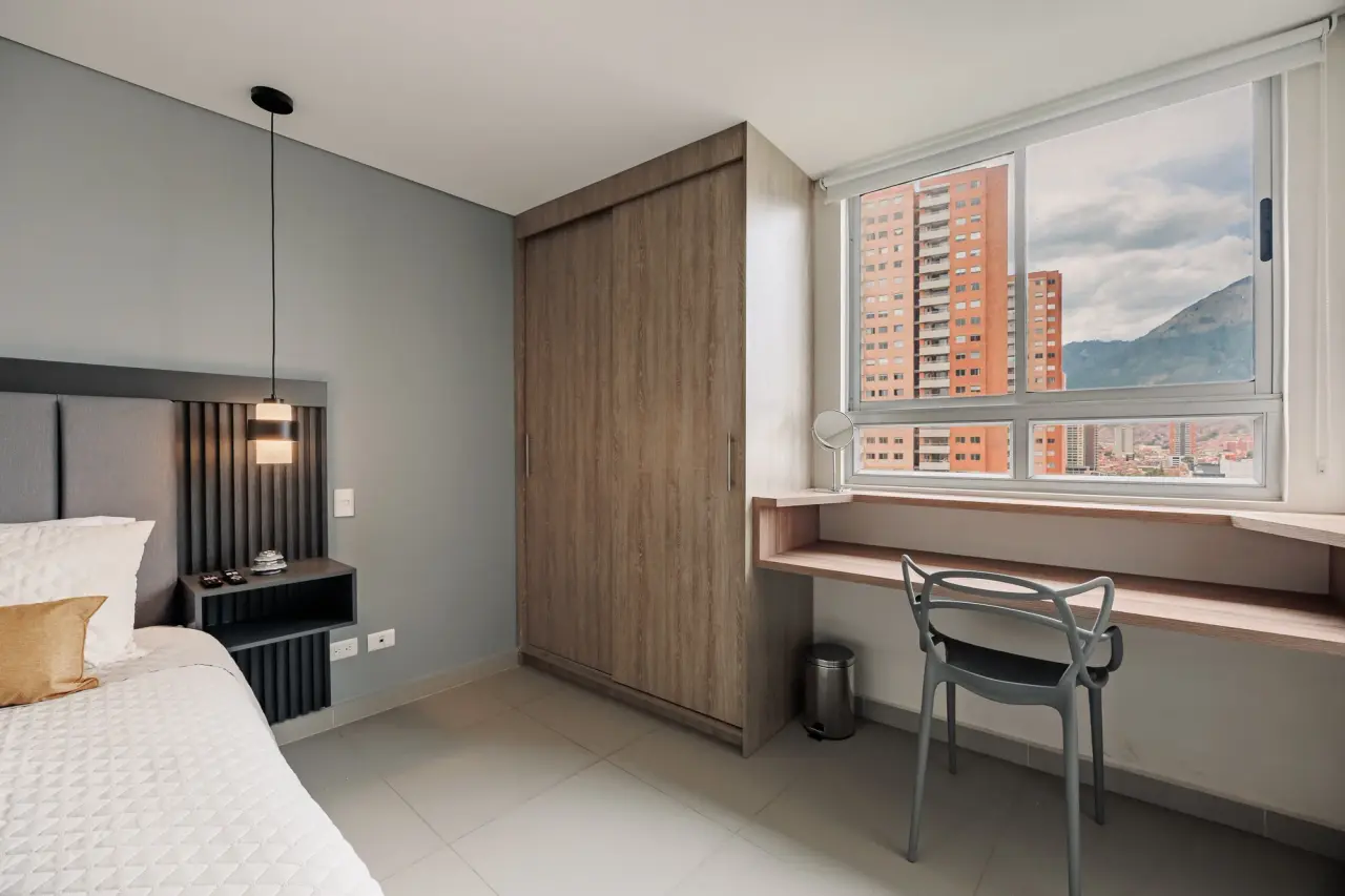 Bedroom desk under the window, with the city outside