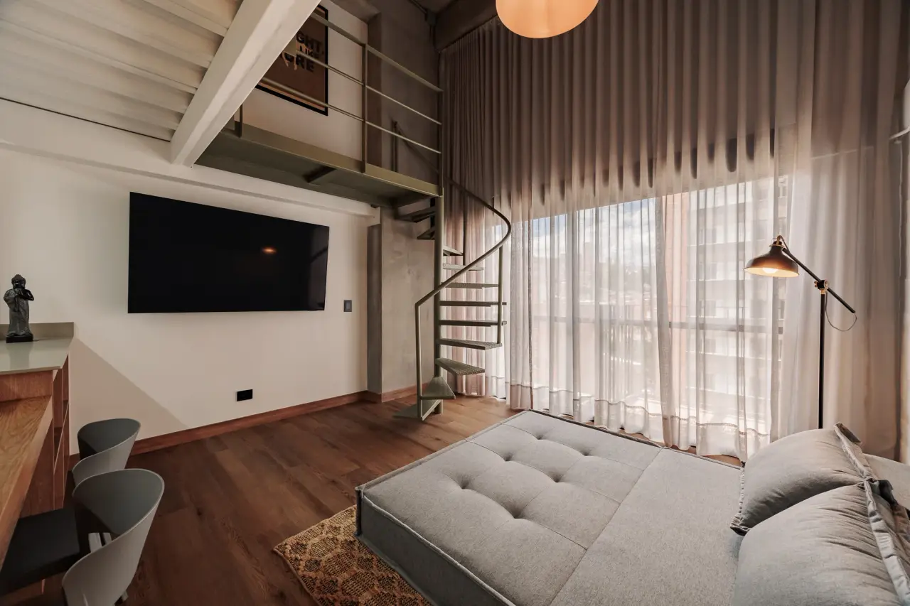 Living room with the sofa bed made flat, beneath the two-story curtains