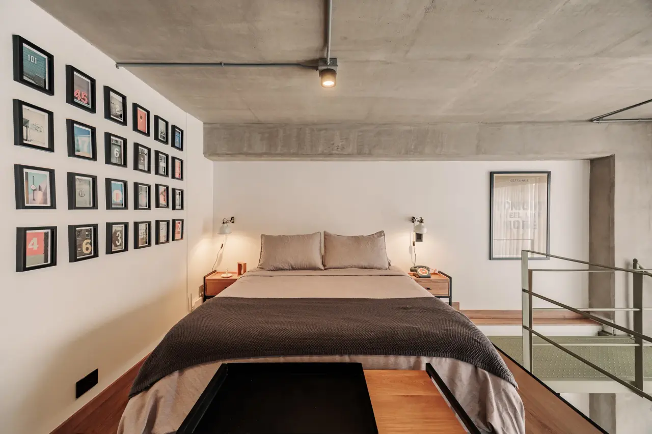 The bedroom’s wall of framed photographs above the bed
