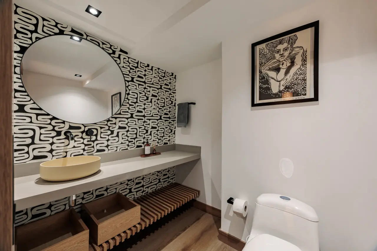The second bathroom, with a round mirror above the patterned tile