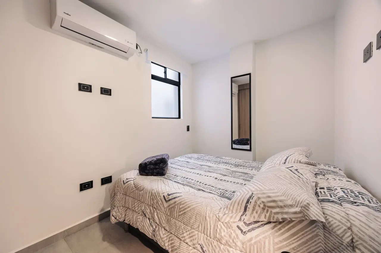 Second bedroom with its bed and air conditioning