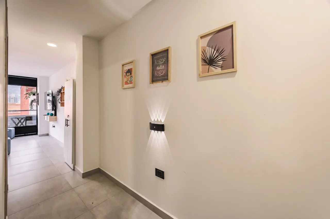 Hallway with framed prints, leading to the balcony