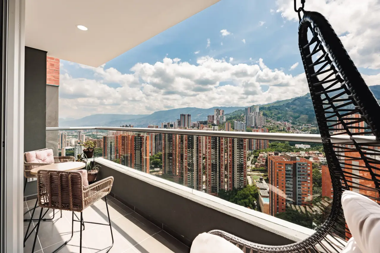 The balcony seen from the living room, with the hanging chair and two bistro chairs