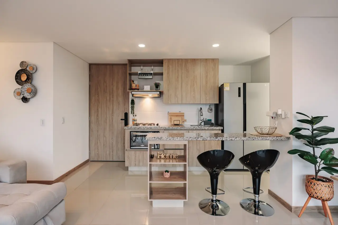 Kitchen with granite bar, bar stools and the door to the balcony