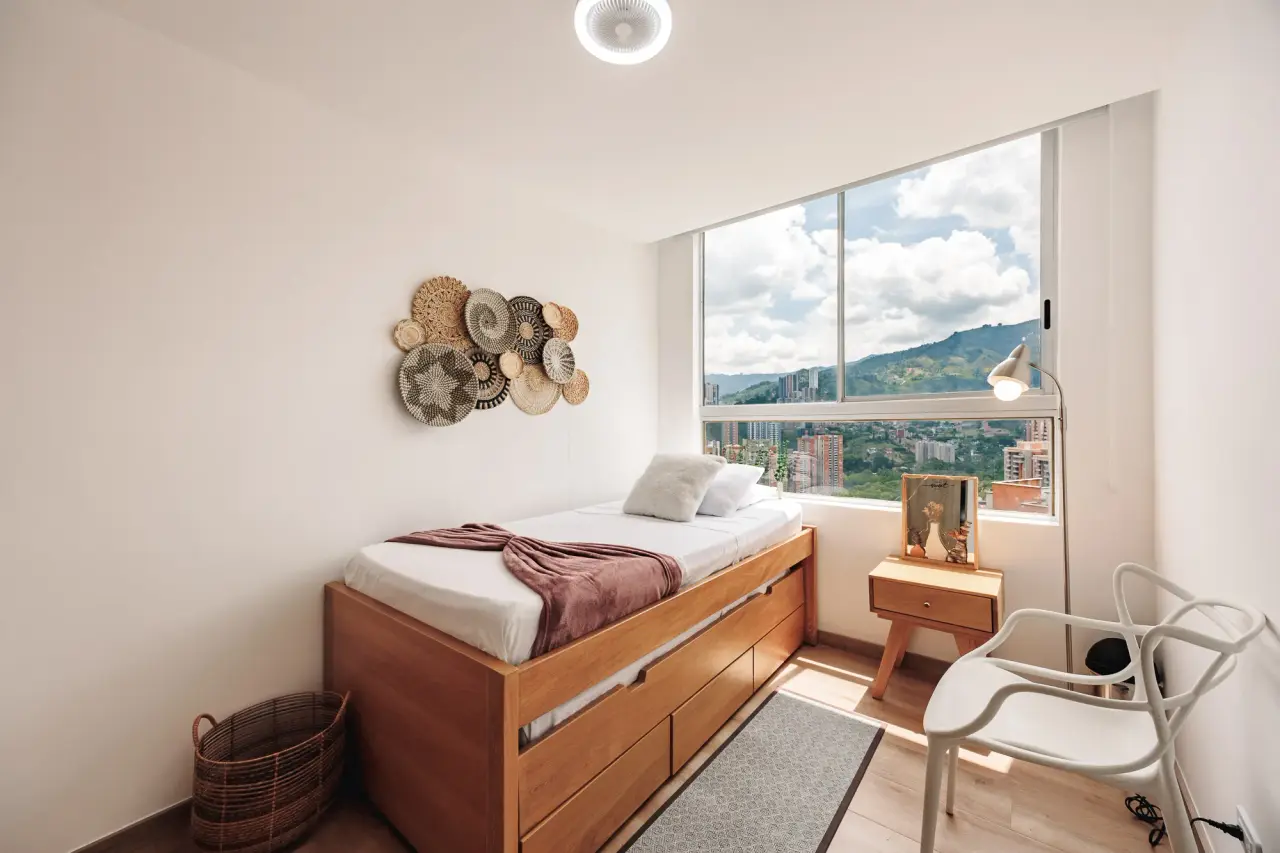 Second bedroom: single bed with drawers underneath and a small desk by the window