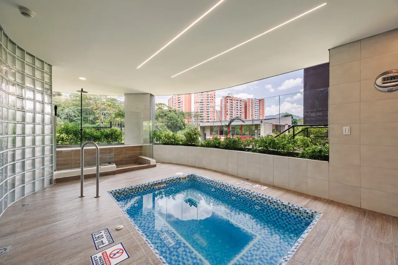 The complex's pool behind a glass-block wall, open to the towers